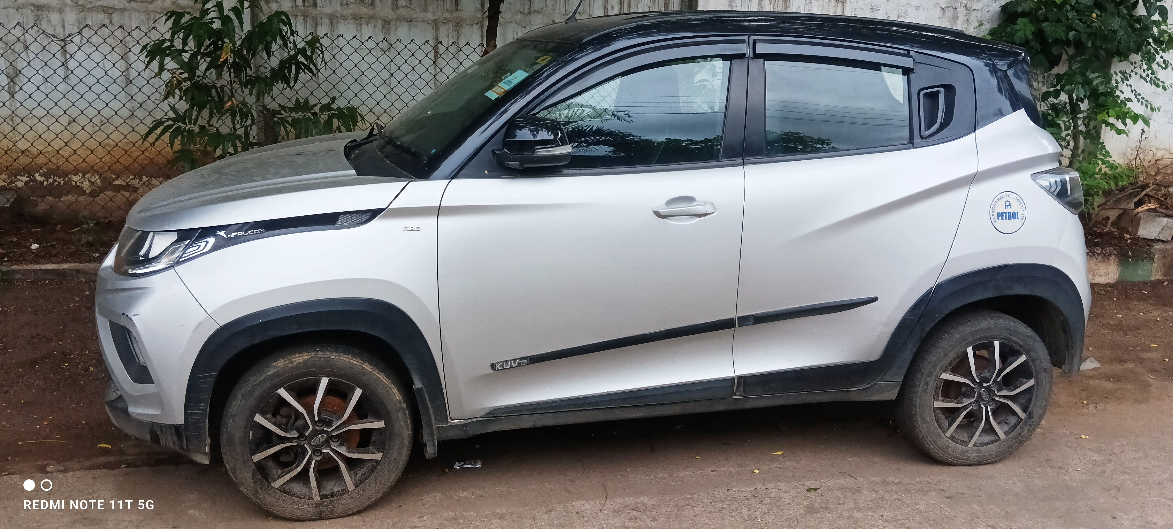 Side view of a dazzling silver with metallic black Mahindra KUV 100 NXT