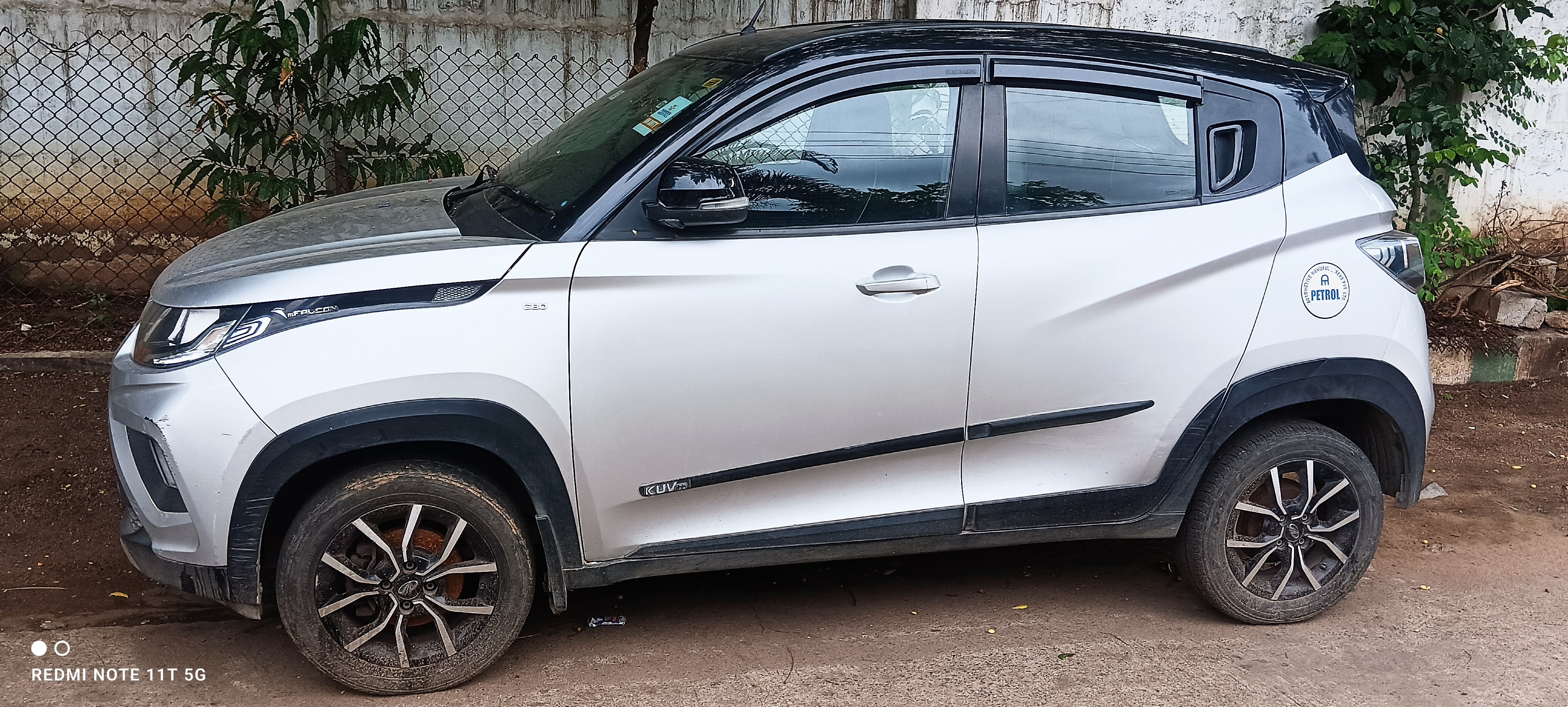 Side view of a dazzling silver with metallic black Mahindra KUV 100 NXT