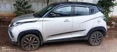 Side view of a dazzling silver with metallic black Mahindra KUV 100 NXT