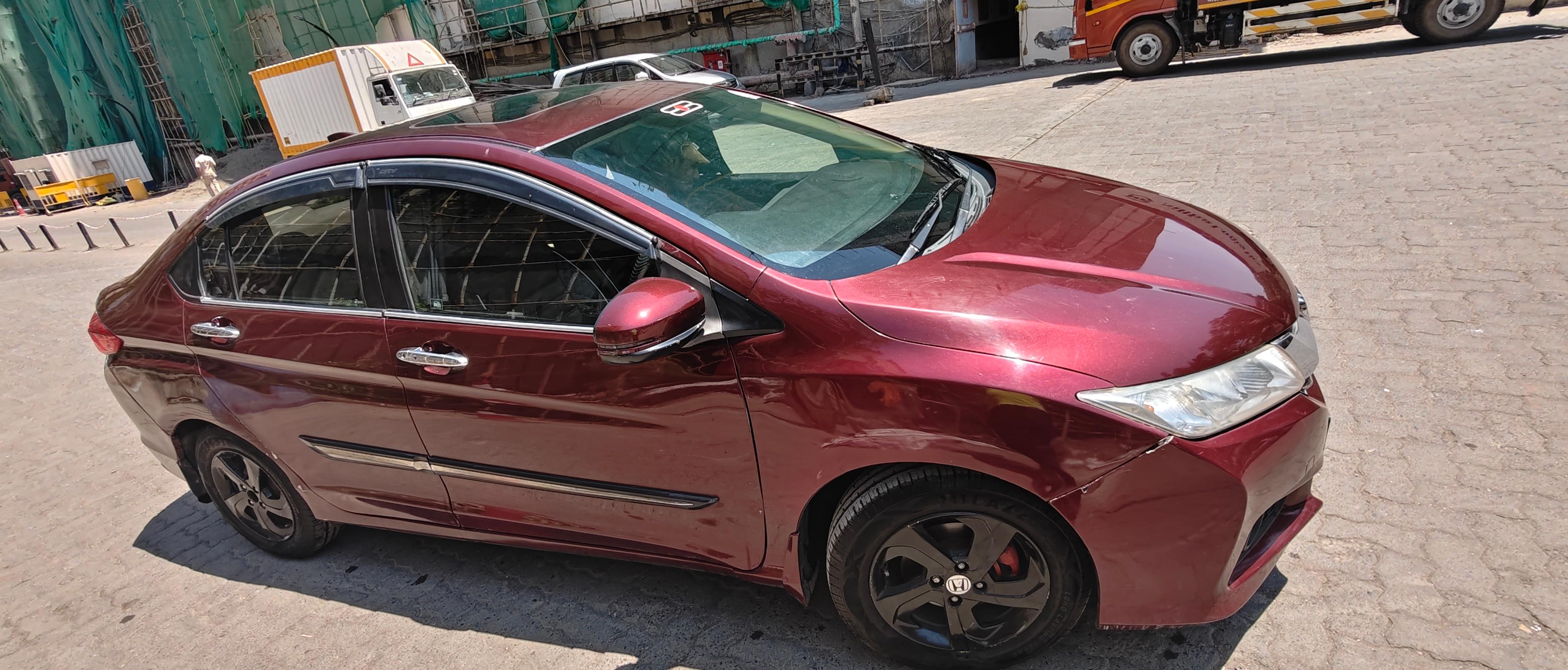 Side view of a radiant red metallic Honda City
