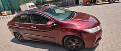 Side view of a radiant red metallic Honda City