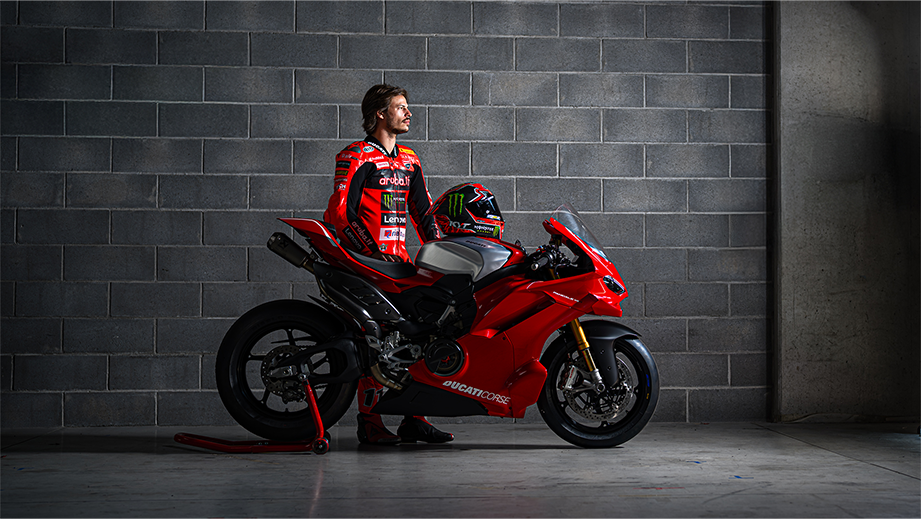 Side view of a Ducati Red Ducati Panigale V4 R motorcycle with rider