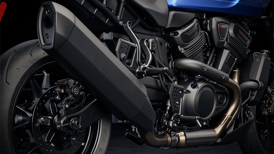 Rear wheel and exhaust detail of a vivid black Harley-Davidson Pan America 1250 ST