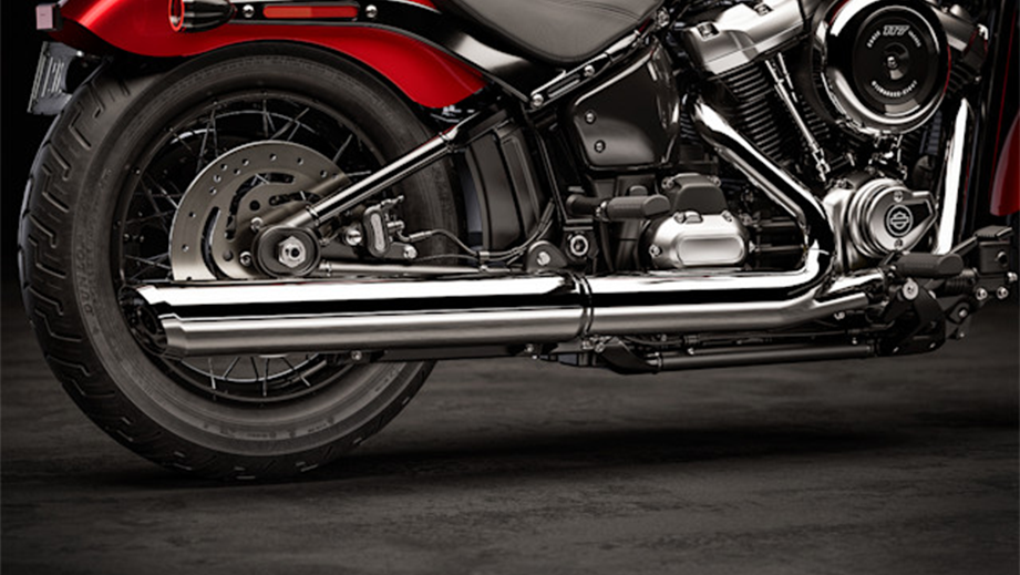 Rear wheel and exhaust view of a brilliant red Harley-Davidson Street Bob