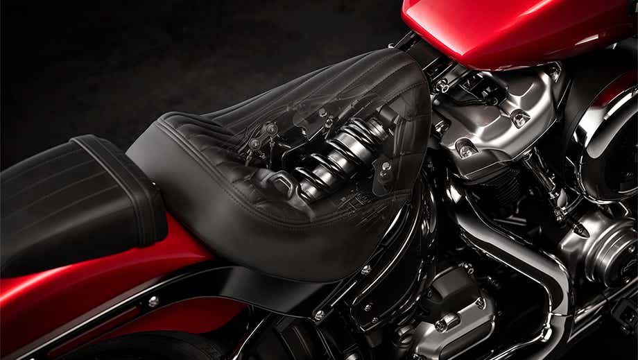 Close-up of seat and suspension area of a brilliant red Harley-Davidson Street Bob