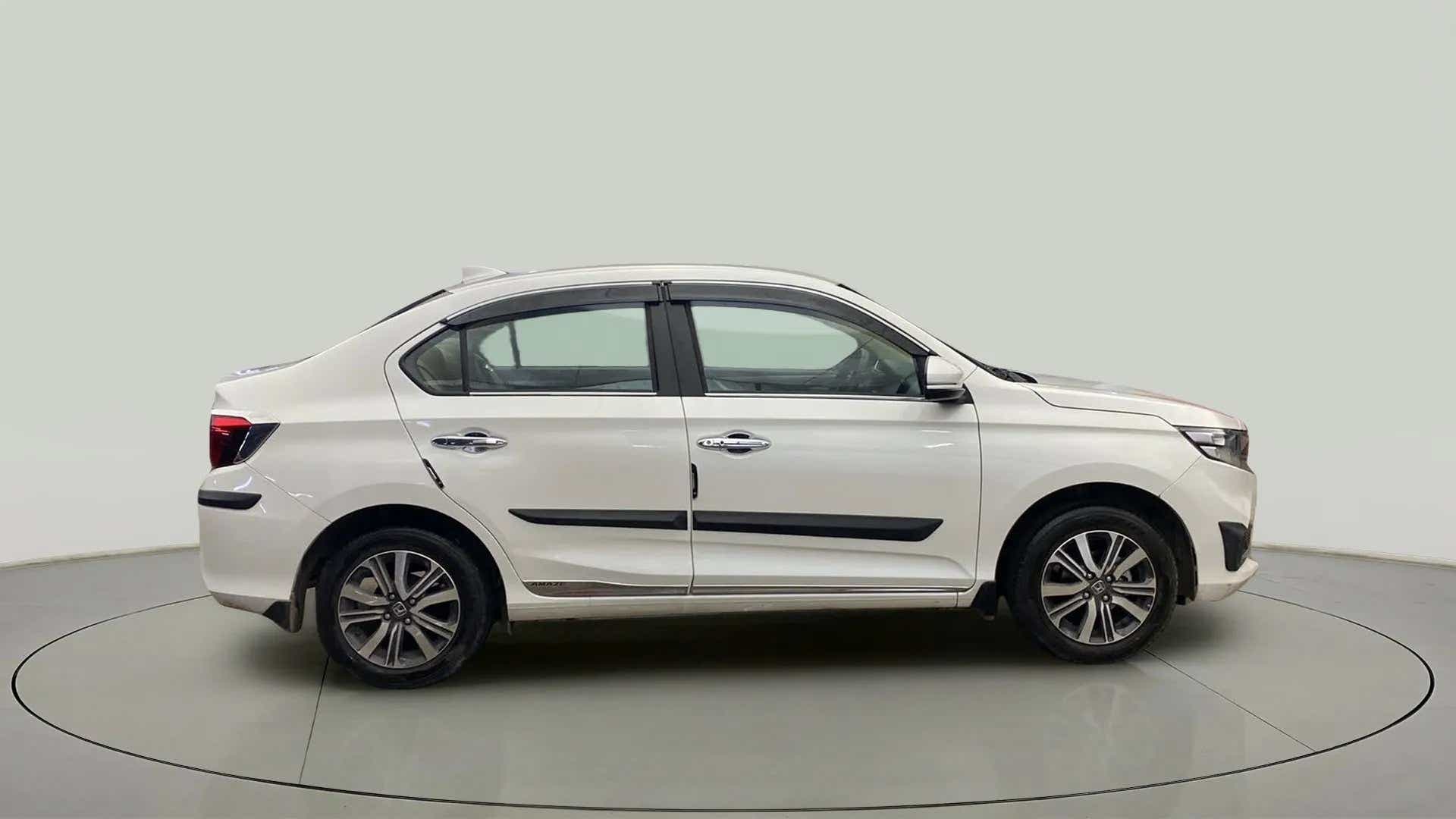 Side view of a platinum white pearl Honda Amaze