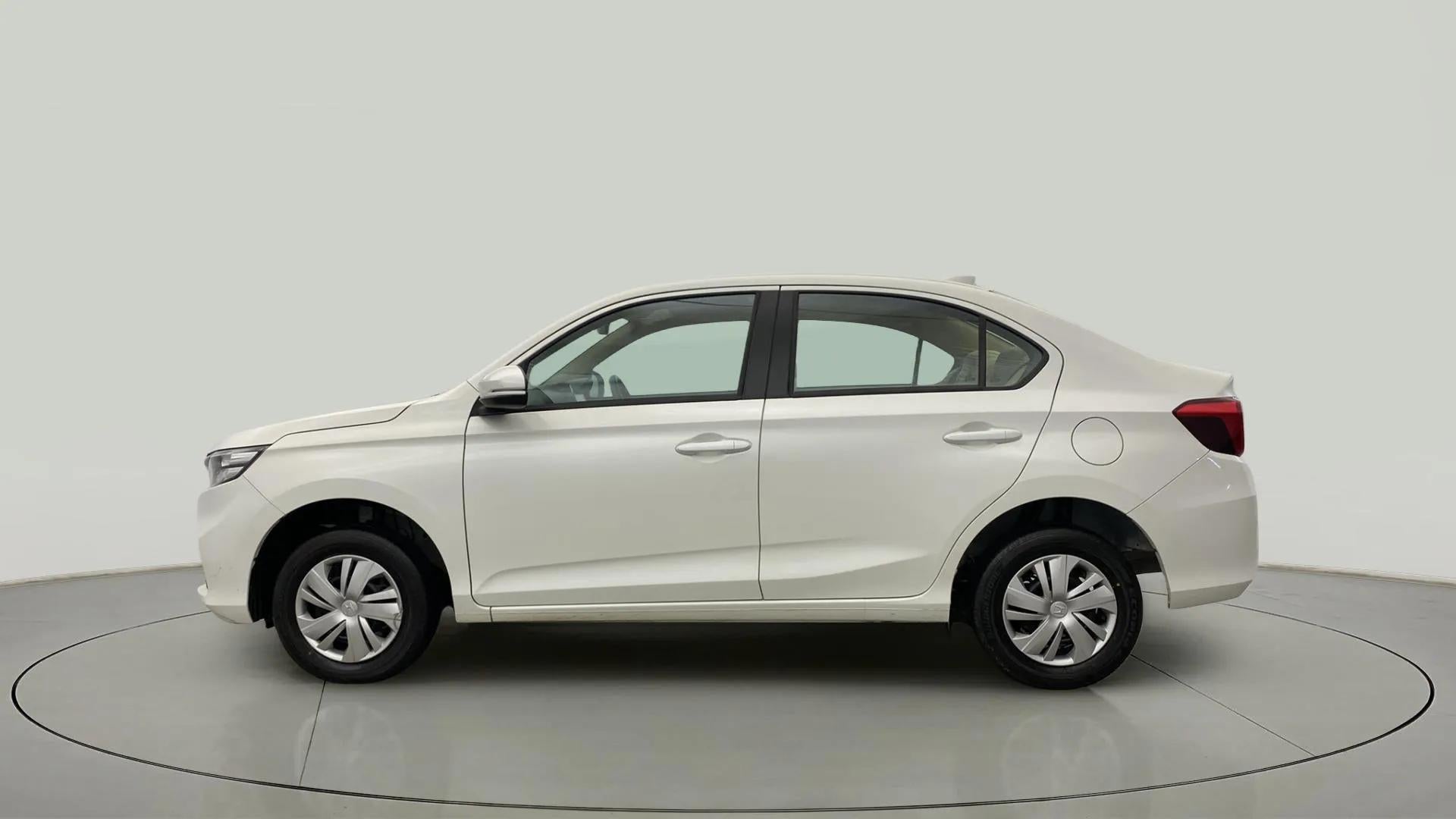 Side view of a platinum white pearl Honda Amaze