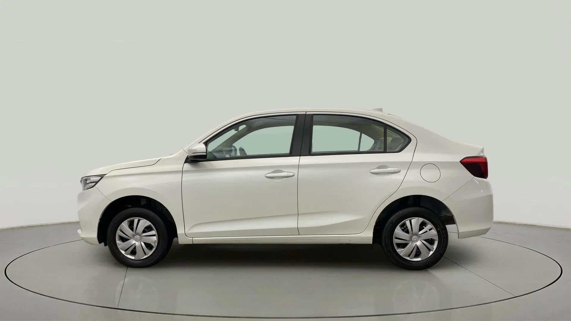 Side view of a platinum white pearl Honda Amaze