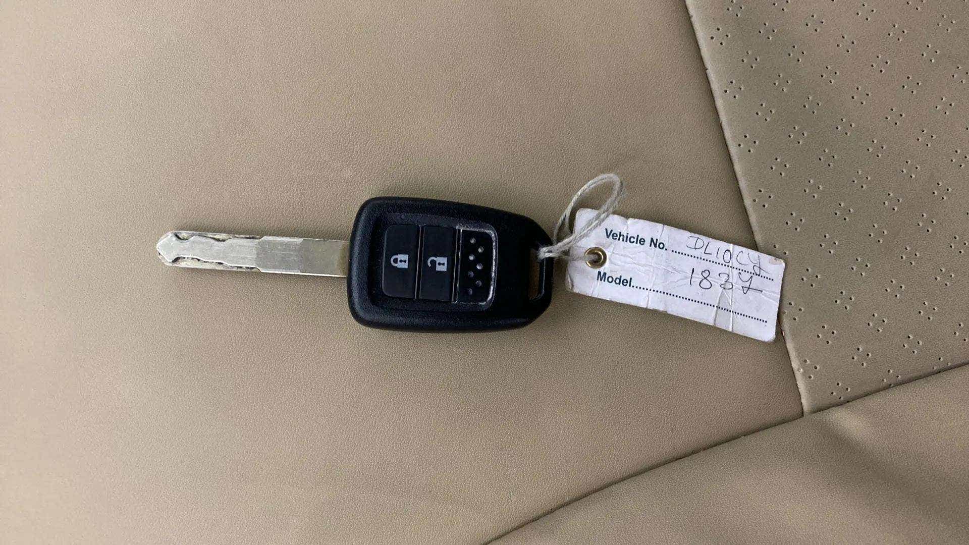 Car key on beige seat of a Honda Amaze