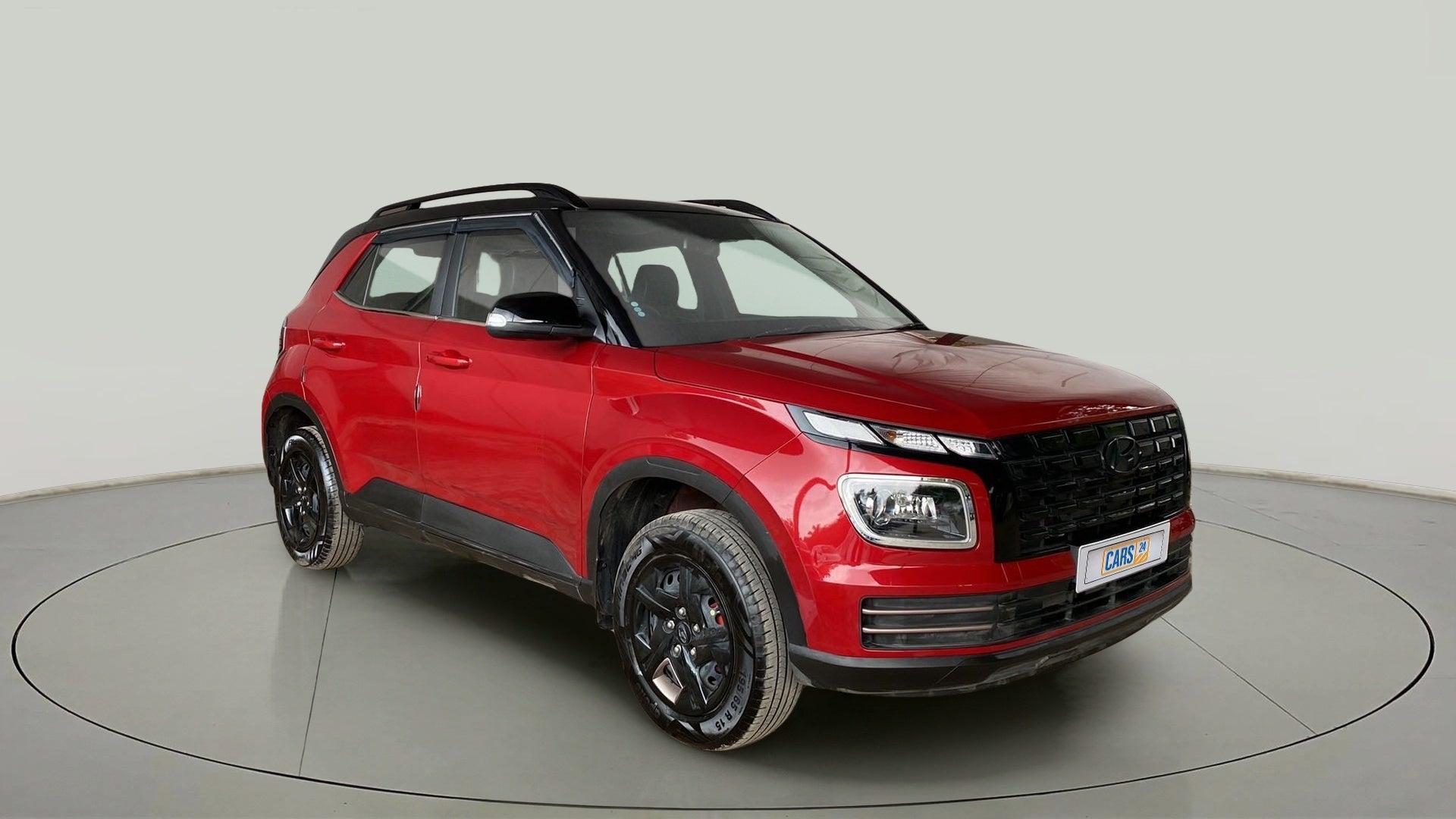 Front three-quarter view of a Fiery Red With Abyss Black Hyundai Venue