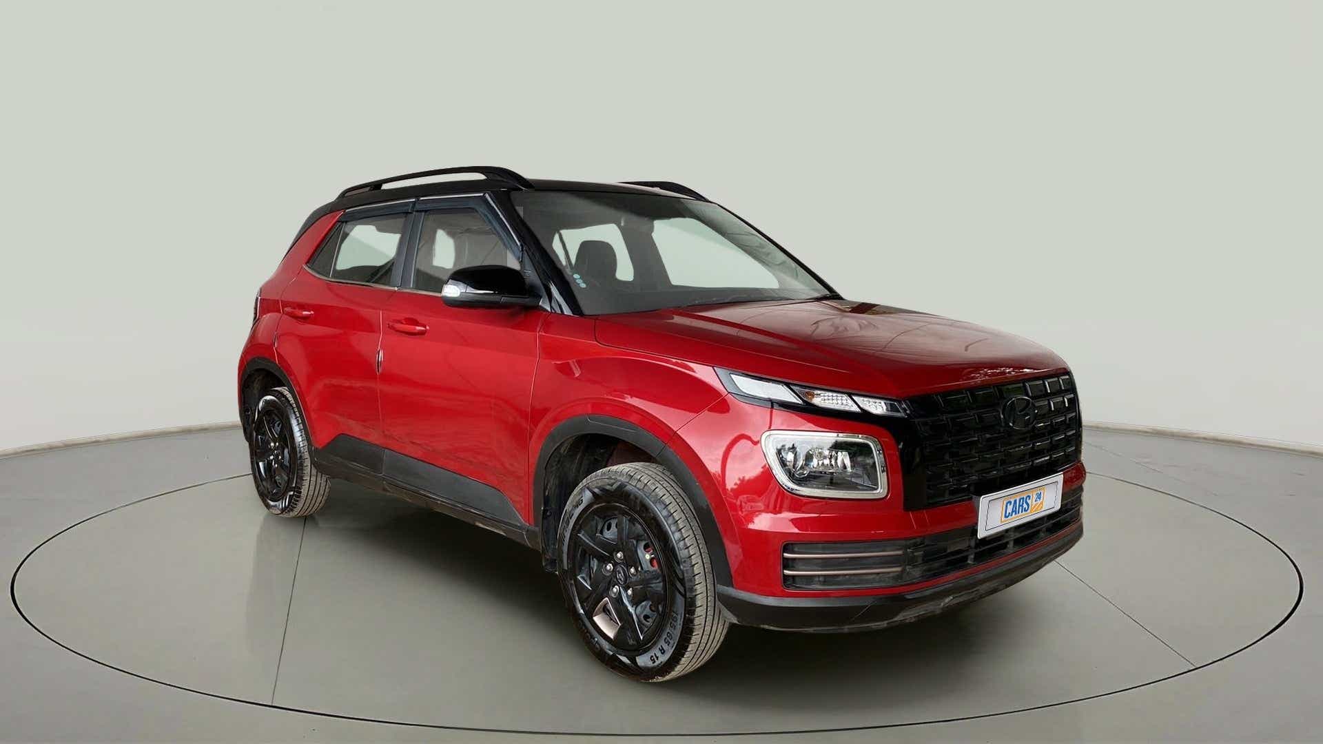 Front three-quarter view of a Fiery Red With Abyss Black Hyundai Venue