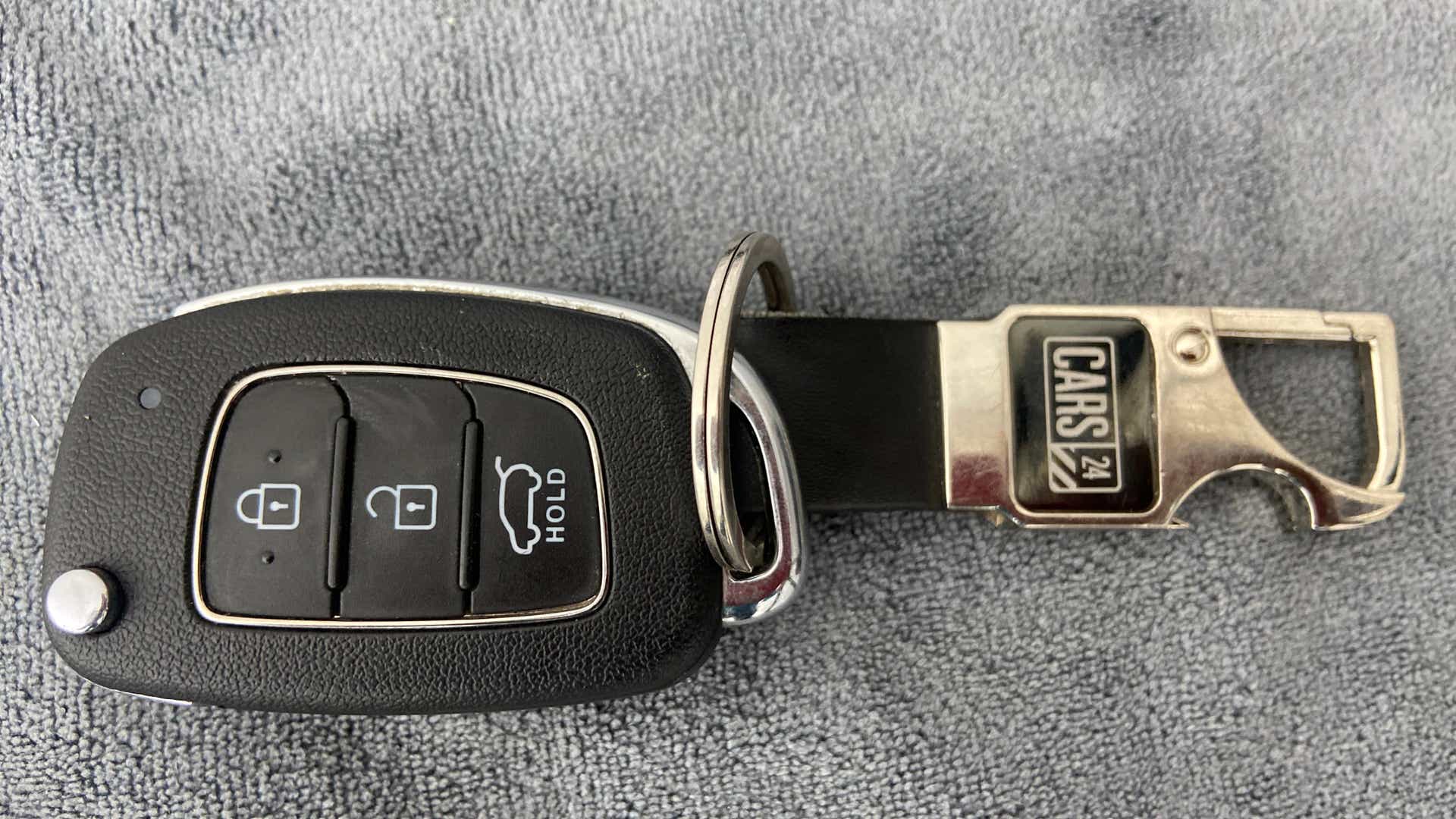 Close-up of a hyundai venue key fob on a textured surface