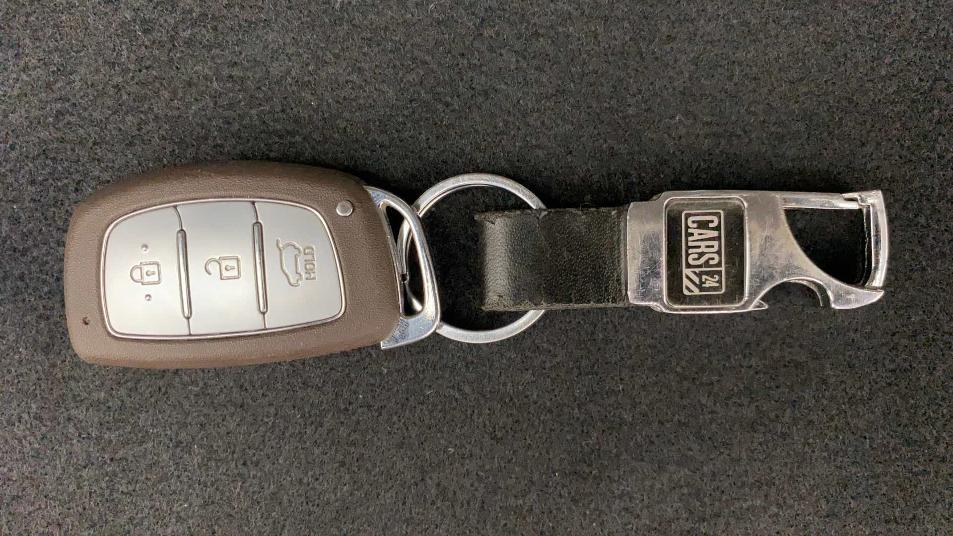 Top view of a hyundai venue car key with a cars24 keychain