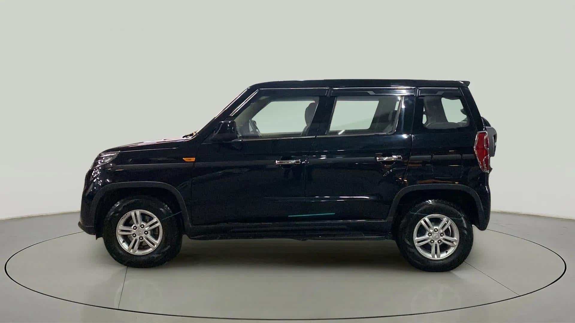 Side profile of a Stealth Black Mahindra Bolero Neo