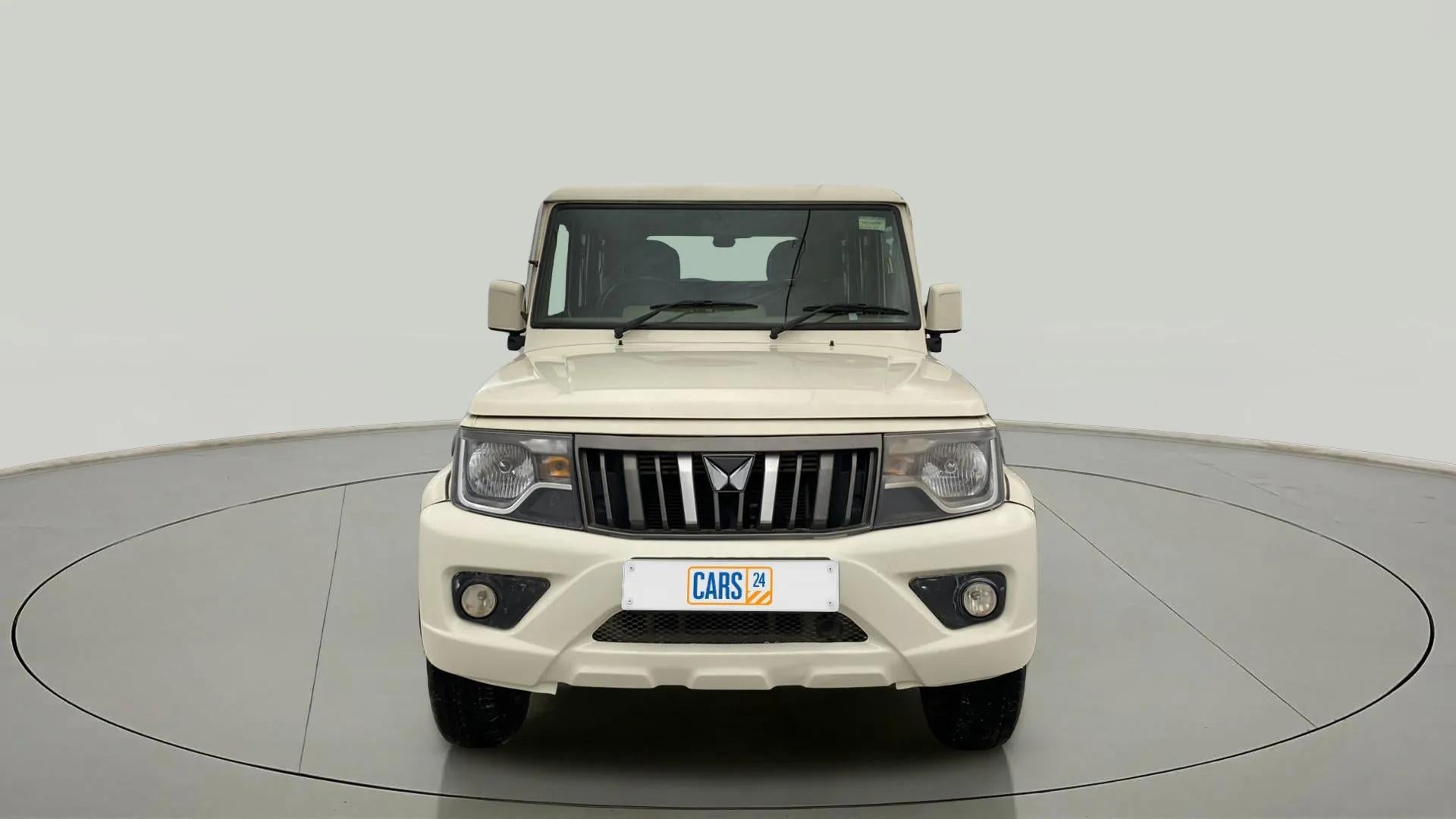 Front view of a diamond white Mahindra Bolero