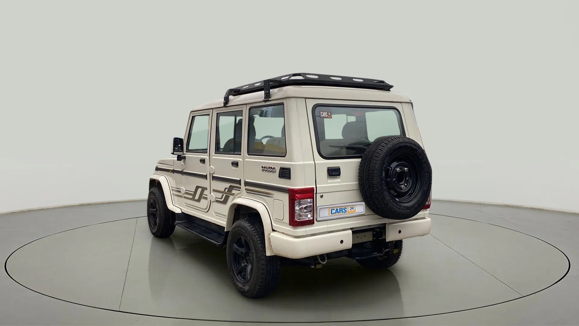 Rear three-quarter view of a diamond white Mahindra Bolero