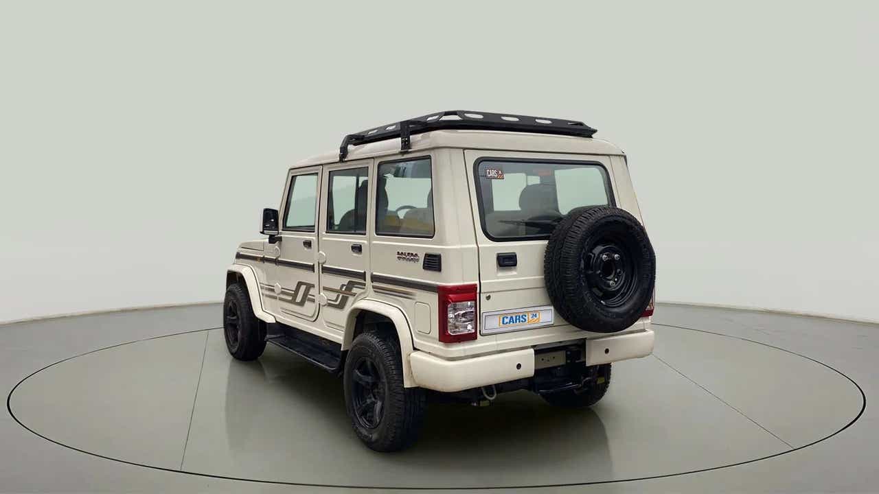 Rear three-quarter view of a diamond white Mahindra Bolero