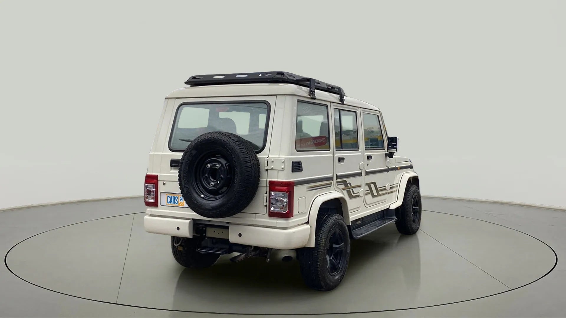 Rear three-quarter view of a diamond white Mahindra Bolero