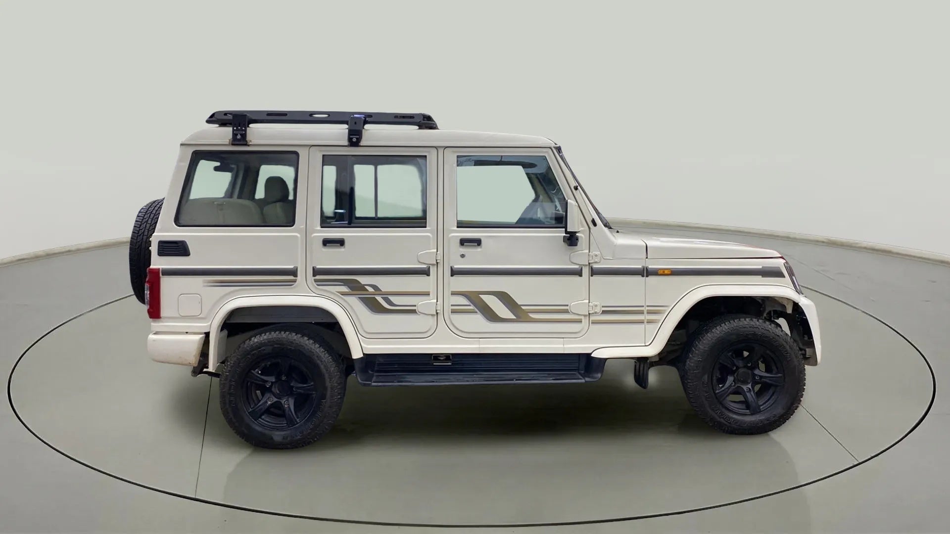 Side view of a diamond white Mahindra Bolero