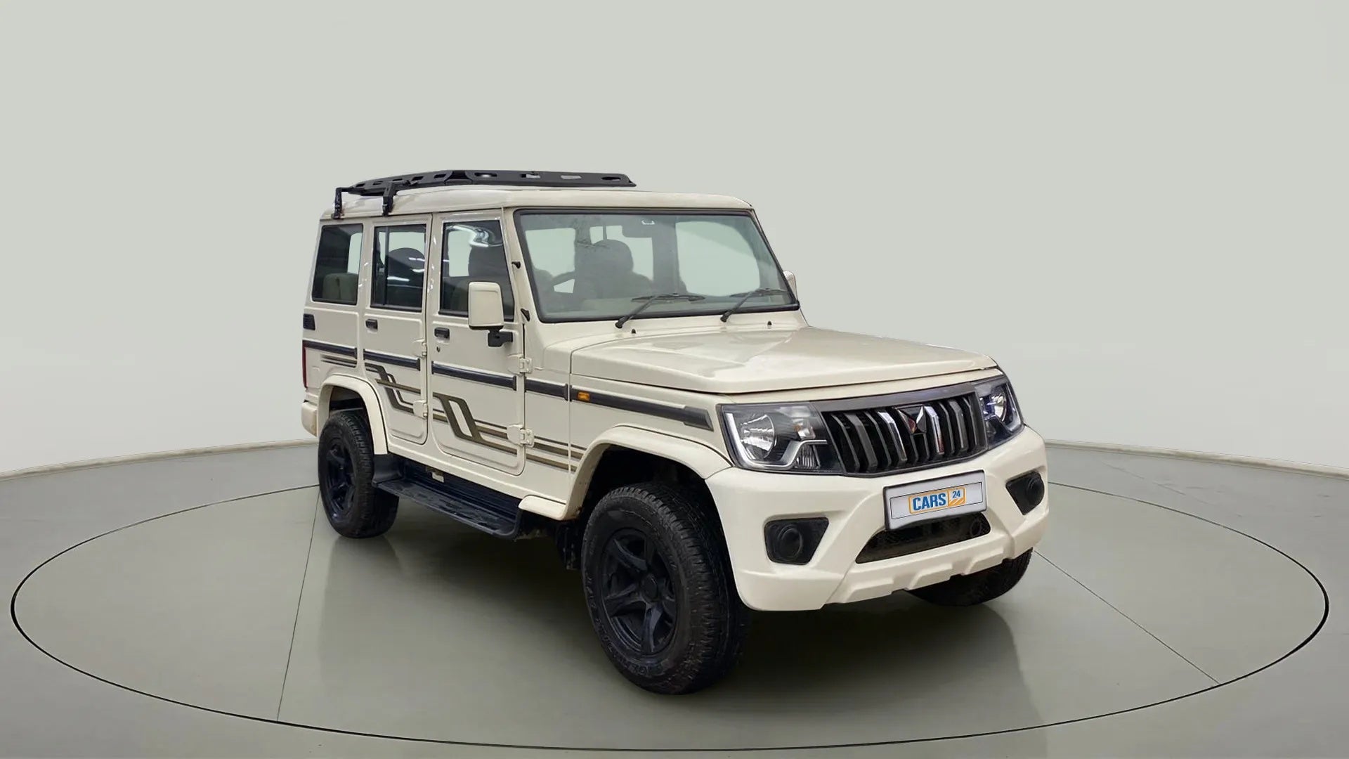 Front three-quarter view of a diamond white Mahindra Bolero
