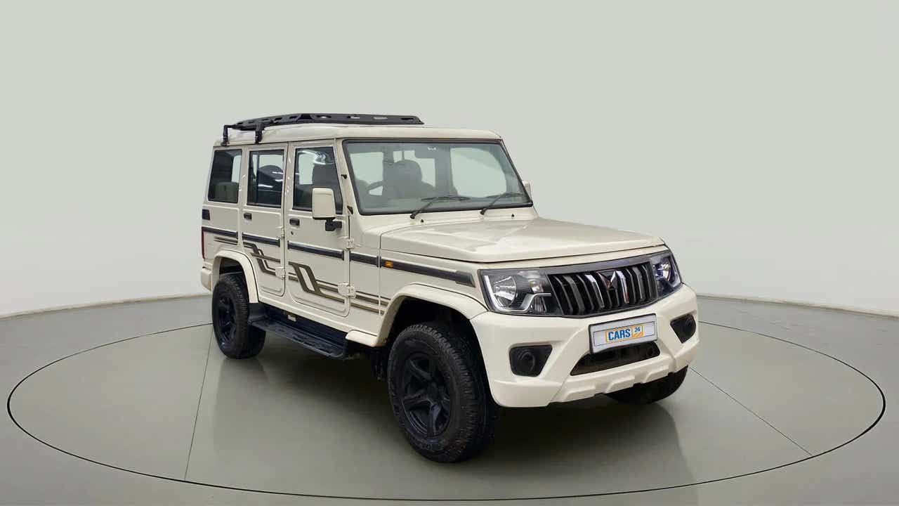 Front three-quarter view of a diamond white Mahindra Bolero