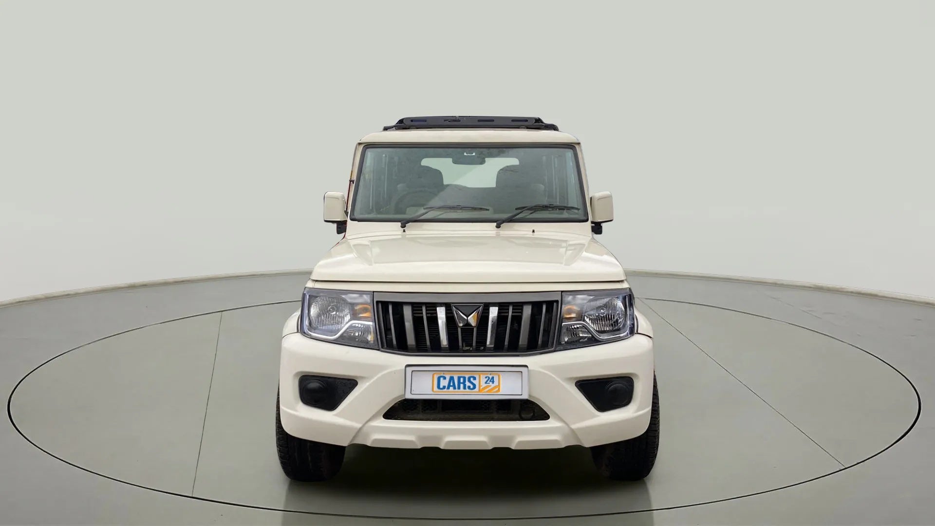 Front view of a diamond white Mahindra Bolero