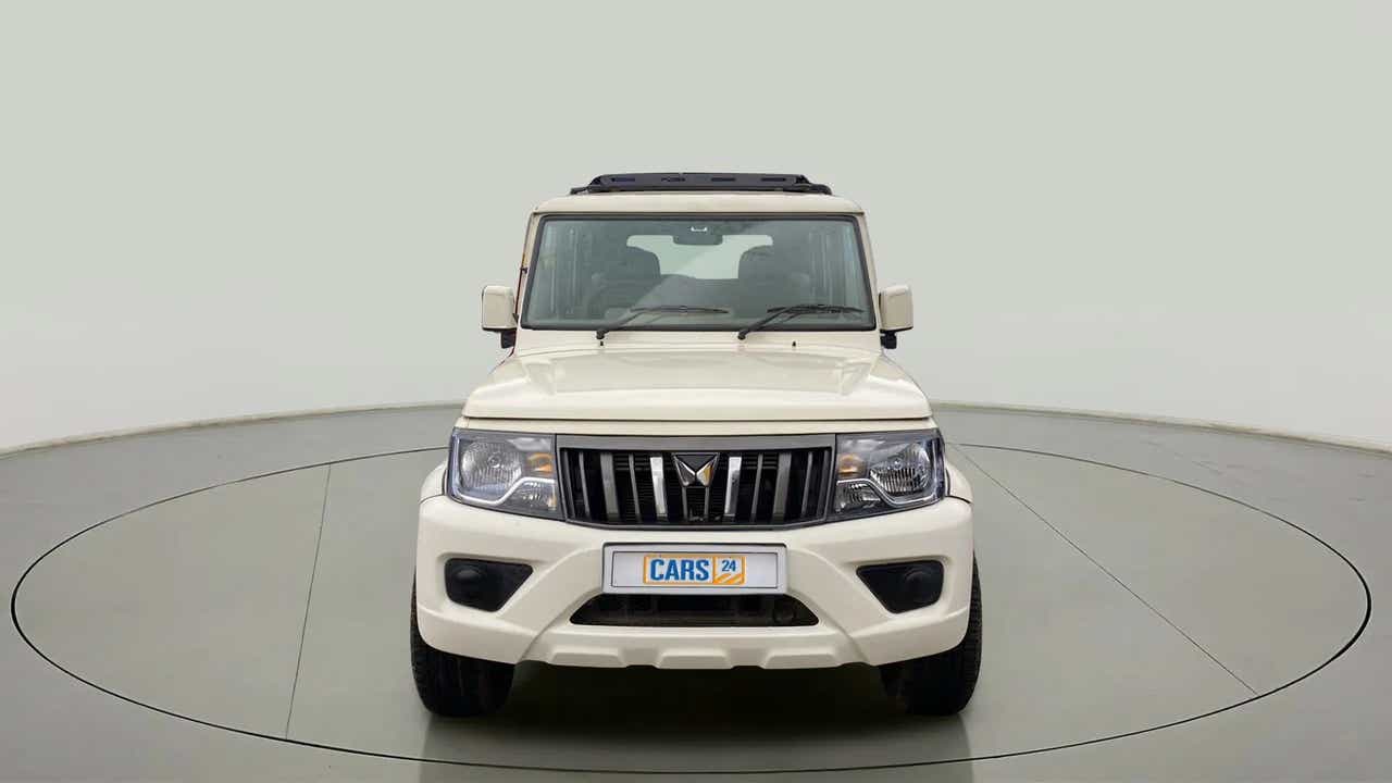 Front view of a diamond white Mahindra Bolero