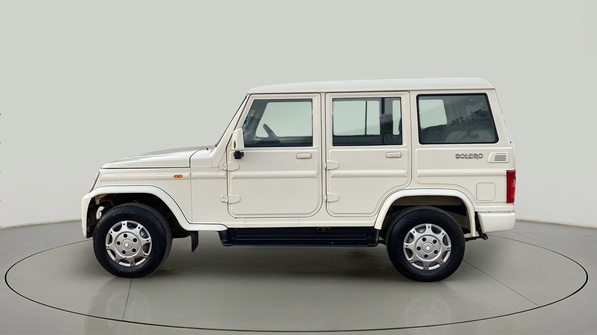 Side view of a diamond white Mahindra Bolero