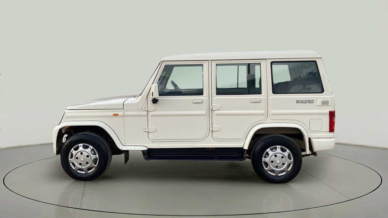 Side view of a diamond white Mahindra Bolero