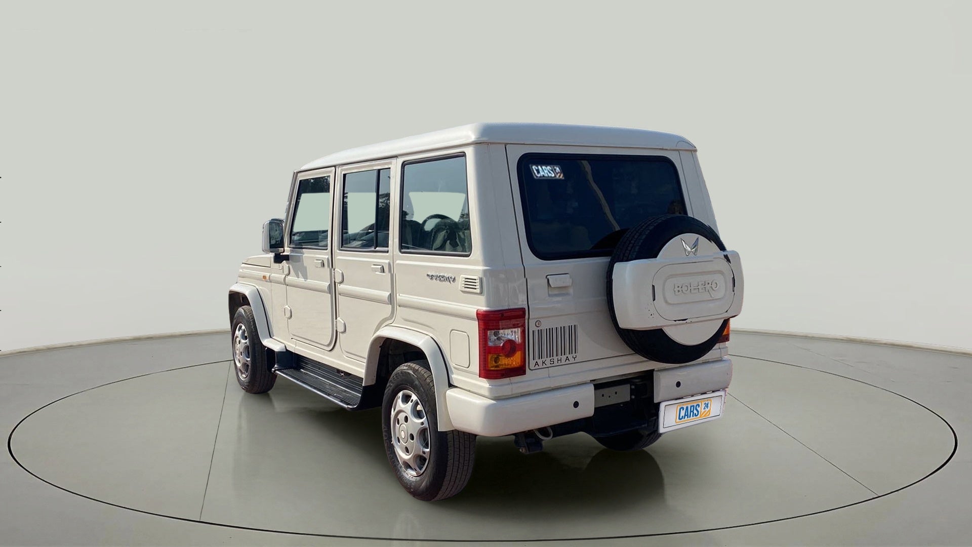 Rear three-quarter view of a diamond white Mahindra Bolero