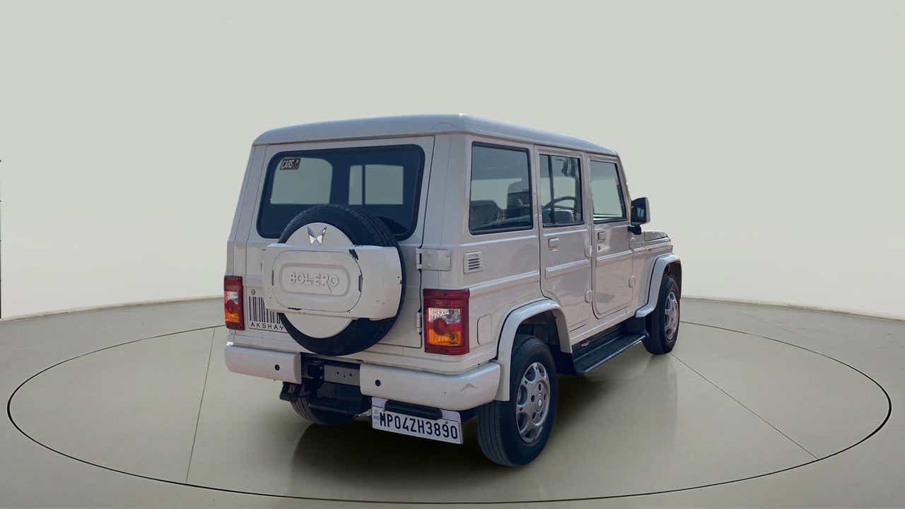 Rear three-quarter view of a diamond white Mahindra Bolero