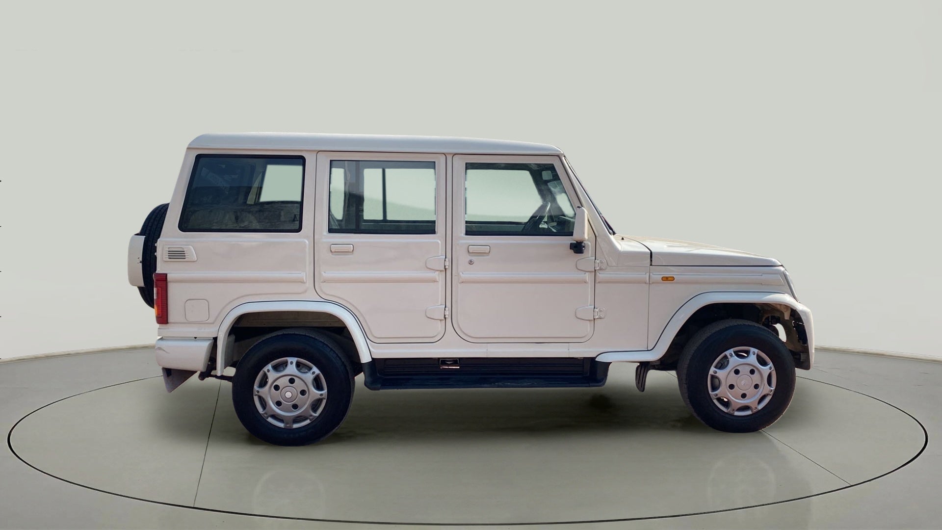 Side view of a diamond white Mahindra Bolero