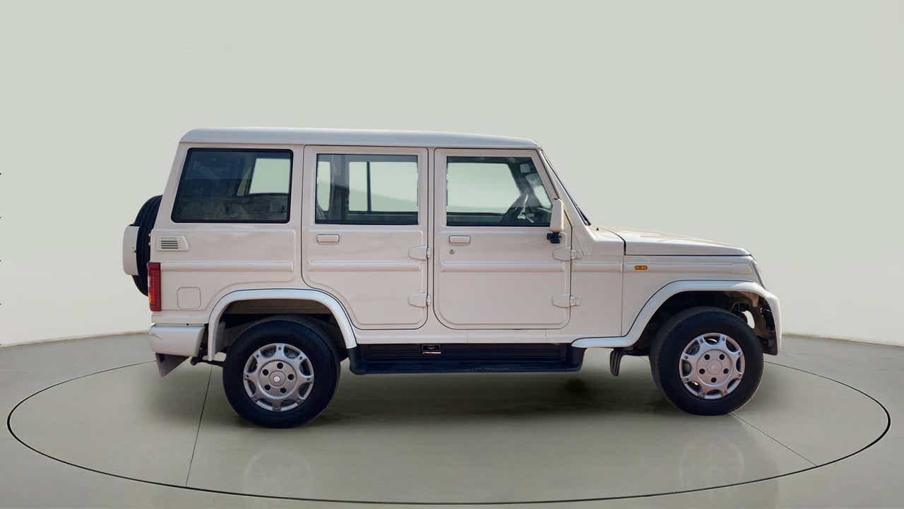Side view of a diamond white Mahindra Bolero