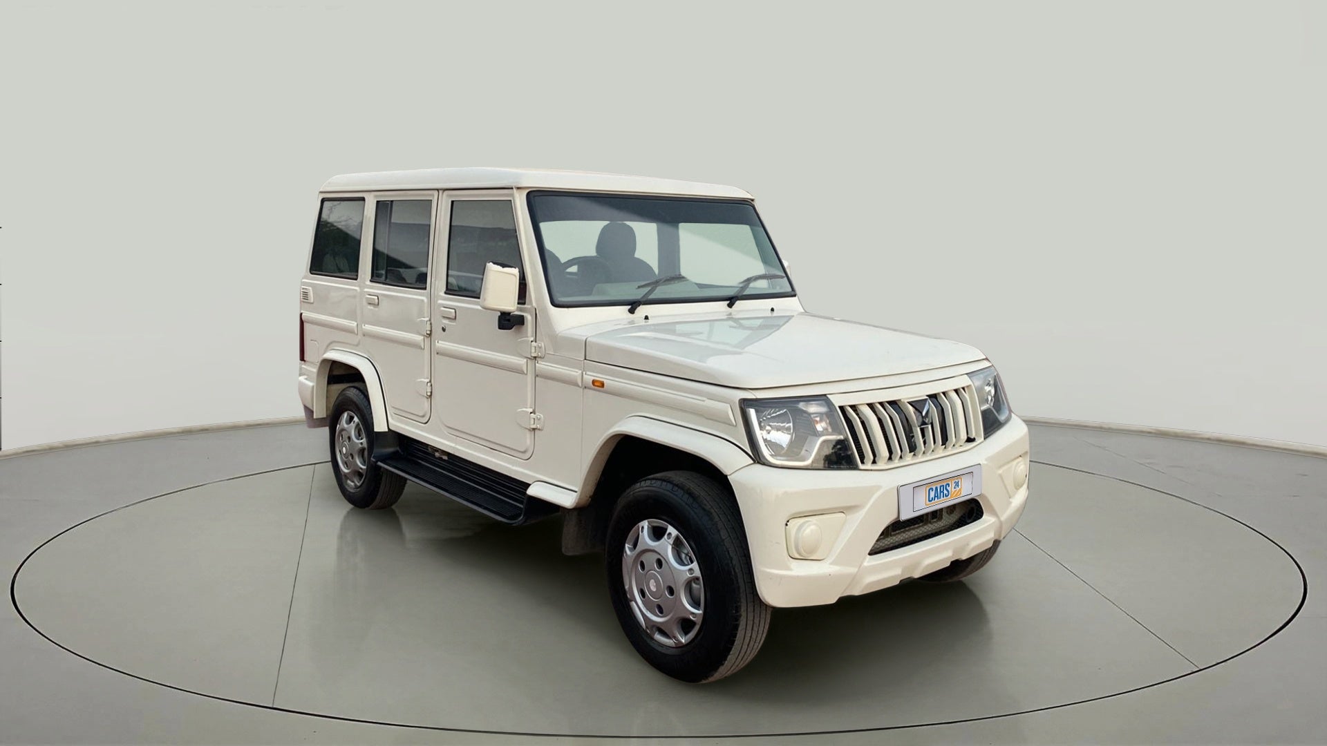 Front three-quarter view of a diamond white Mahindra Bolero