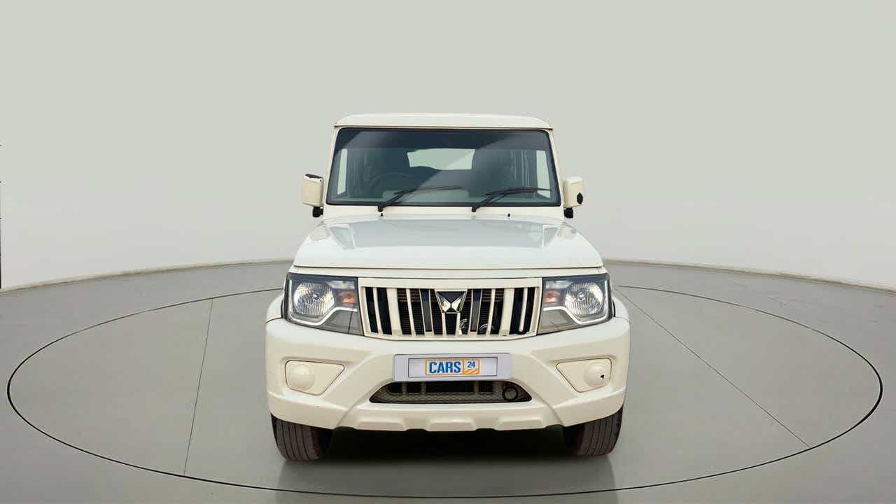 Front view of a diamond white Mahindra Bolero