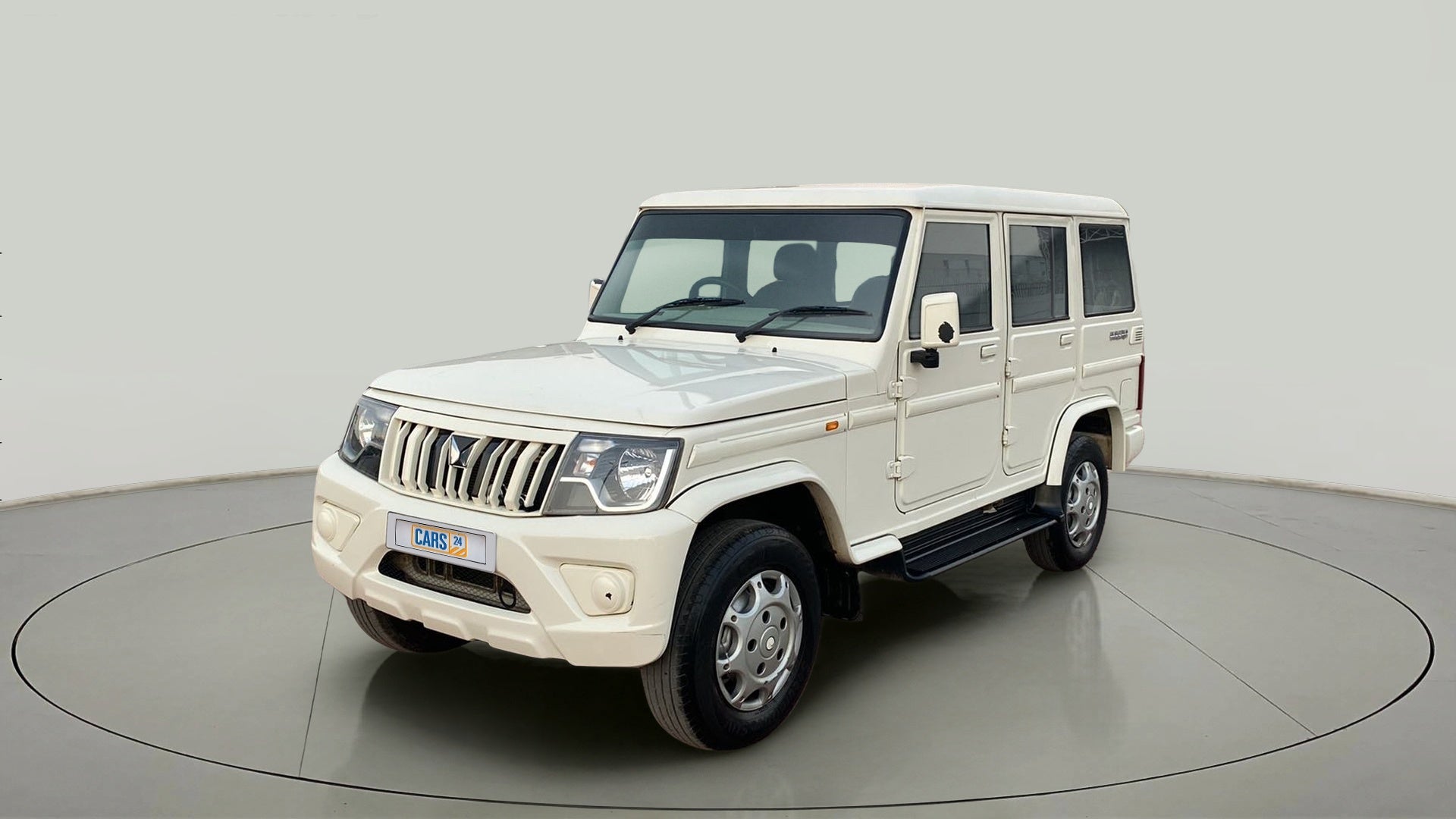 Front three-quarter view of a diamond white Mahindra Bolero