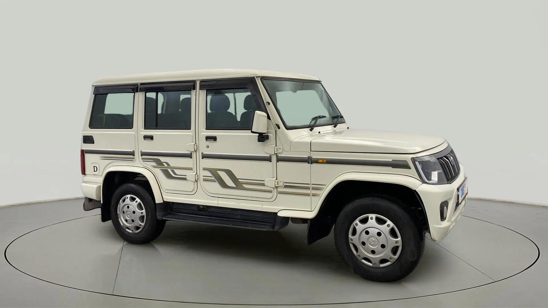 Side view of a diamond white Mahindra Bolero