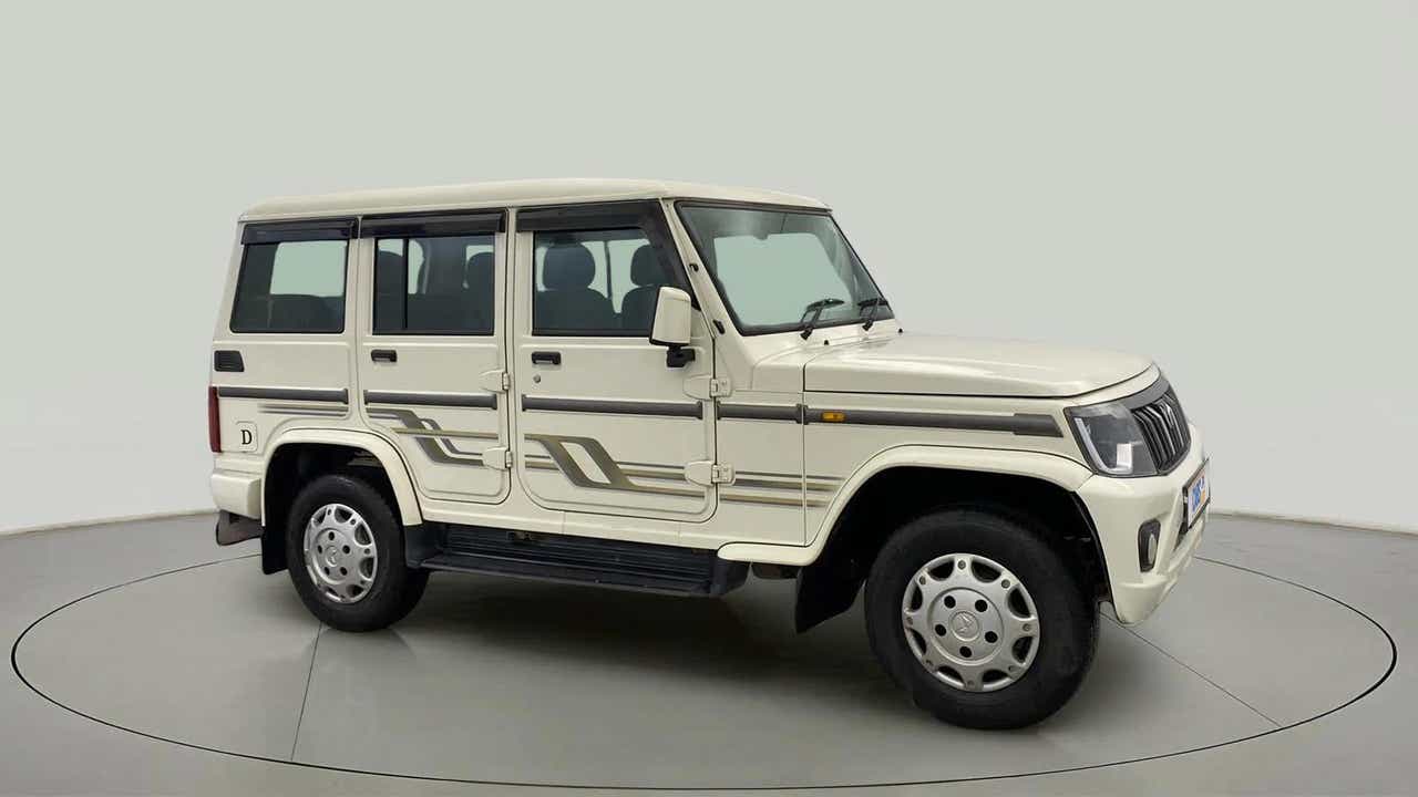 Side view of a diamond white Mahindra Bolero
