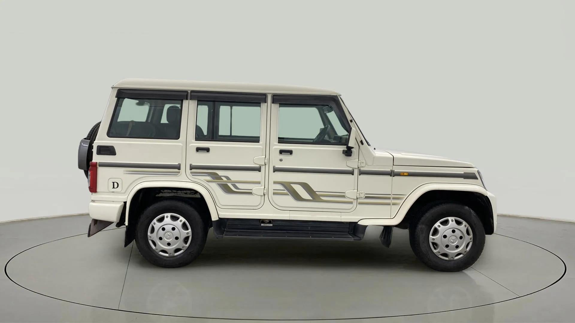 Side view of a diamond white Mahindra Bolero