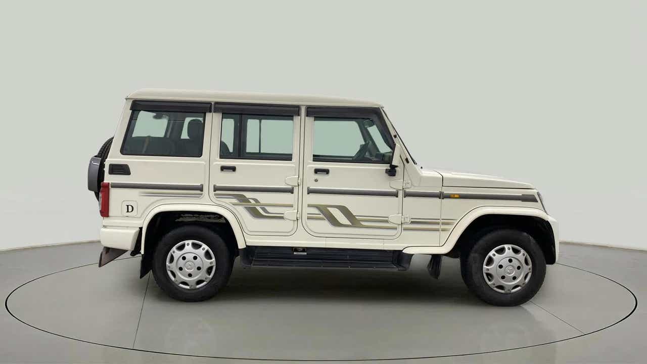 Side view of a diamond white Mahindra Bolero