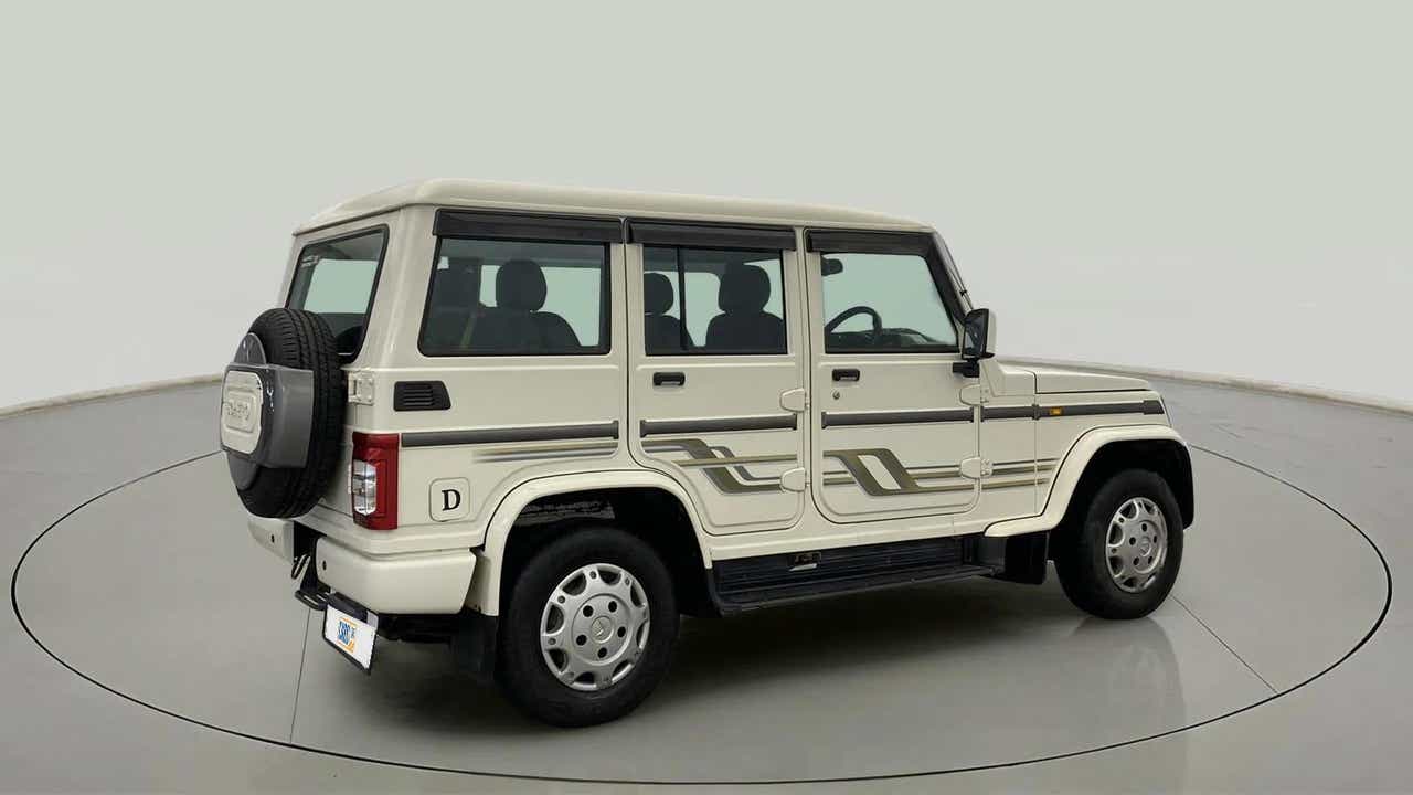 Rear three-quarter view of a diamond white Mahindra Bolero