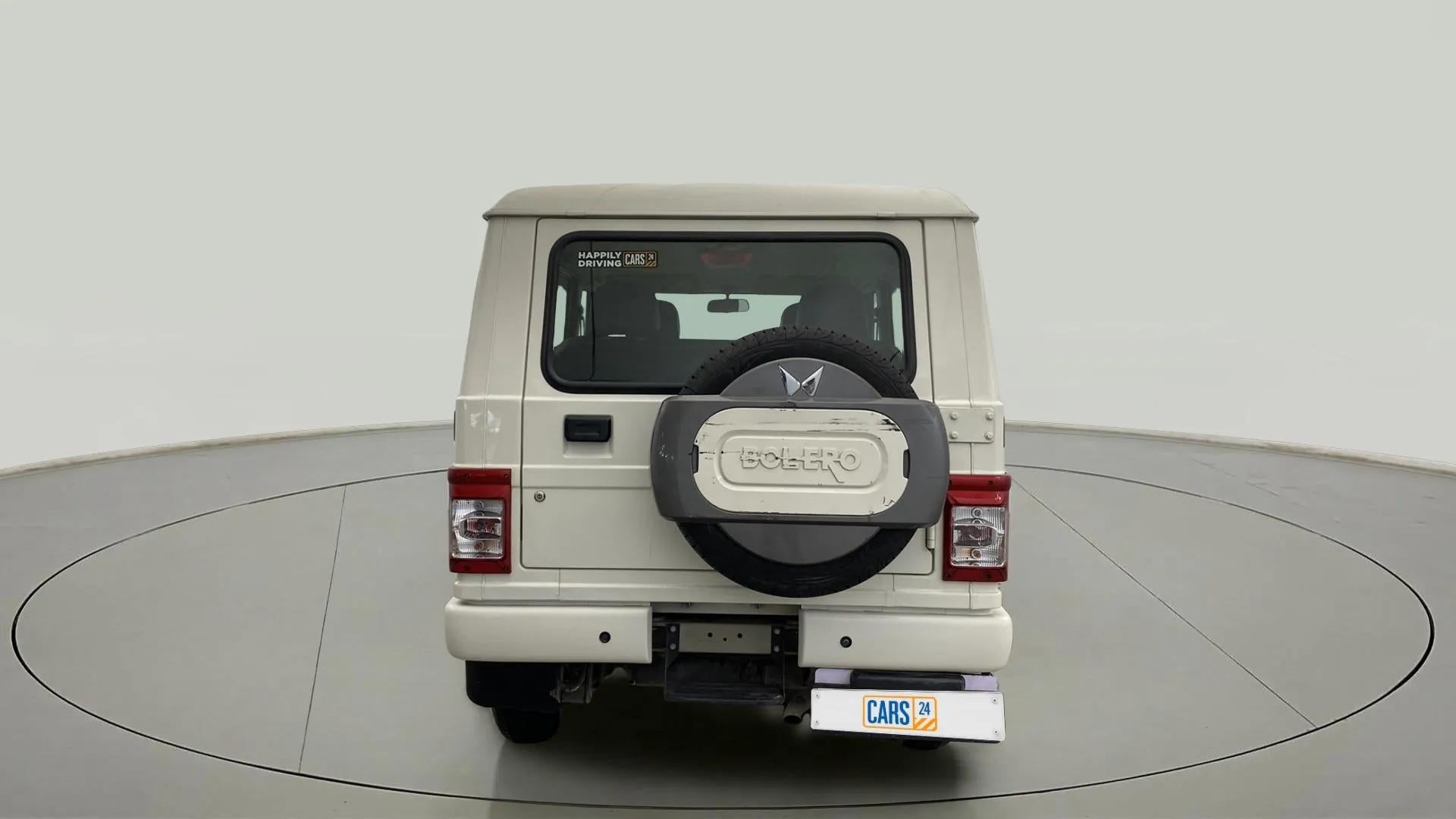 Rear view of a diamond white Mahindra Bolero