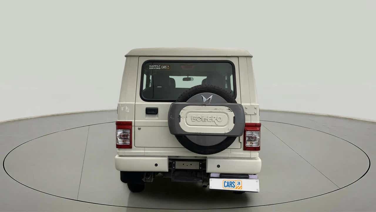 Rear view of a diamond white Mahindra Bolero