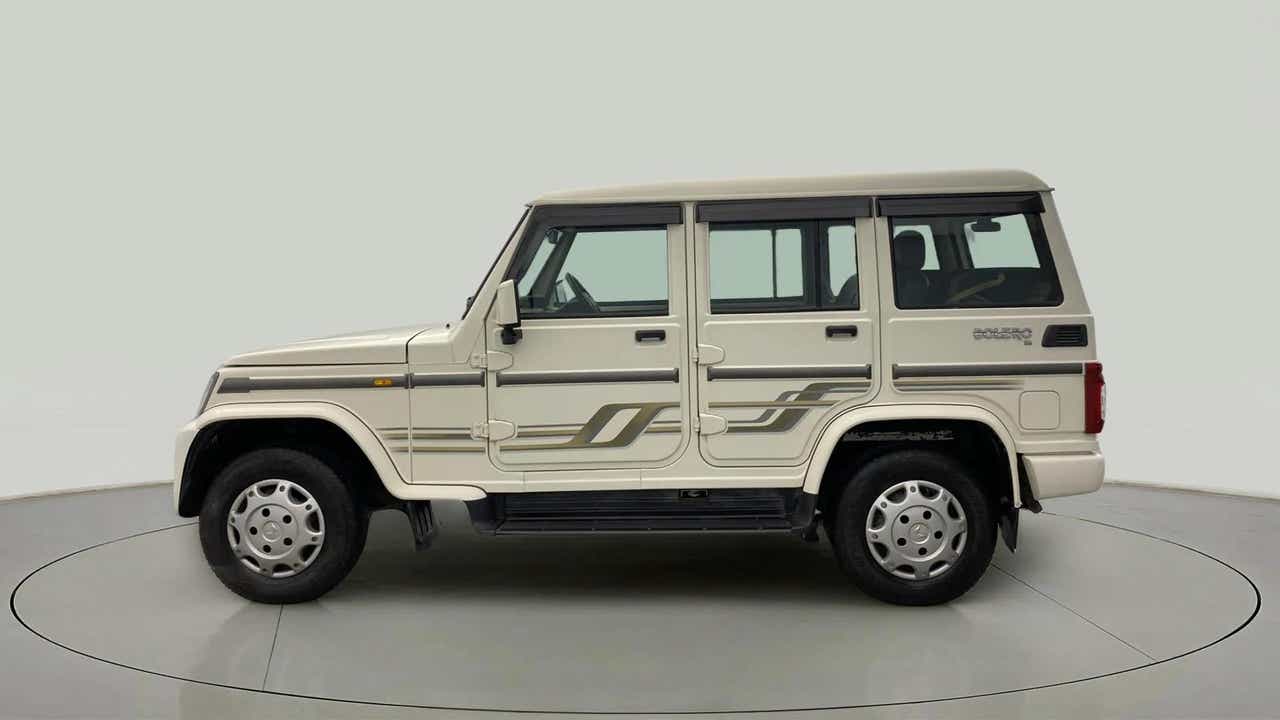 Side view of a diamond white Mahindra Bolero