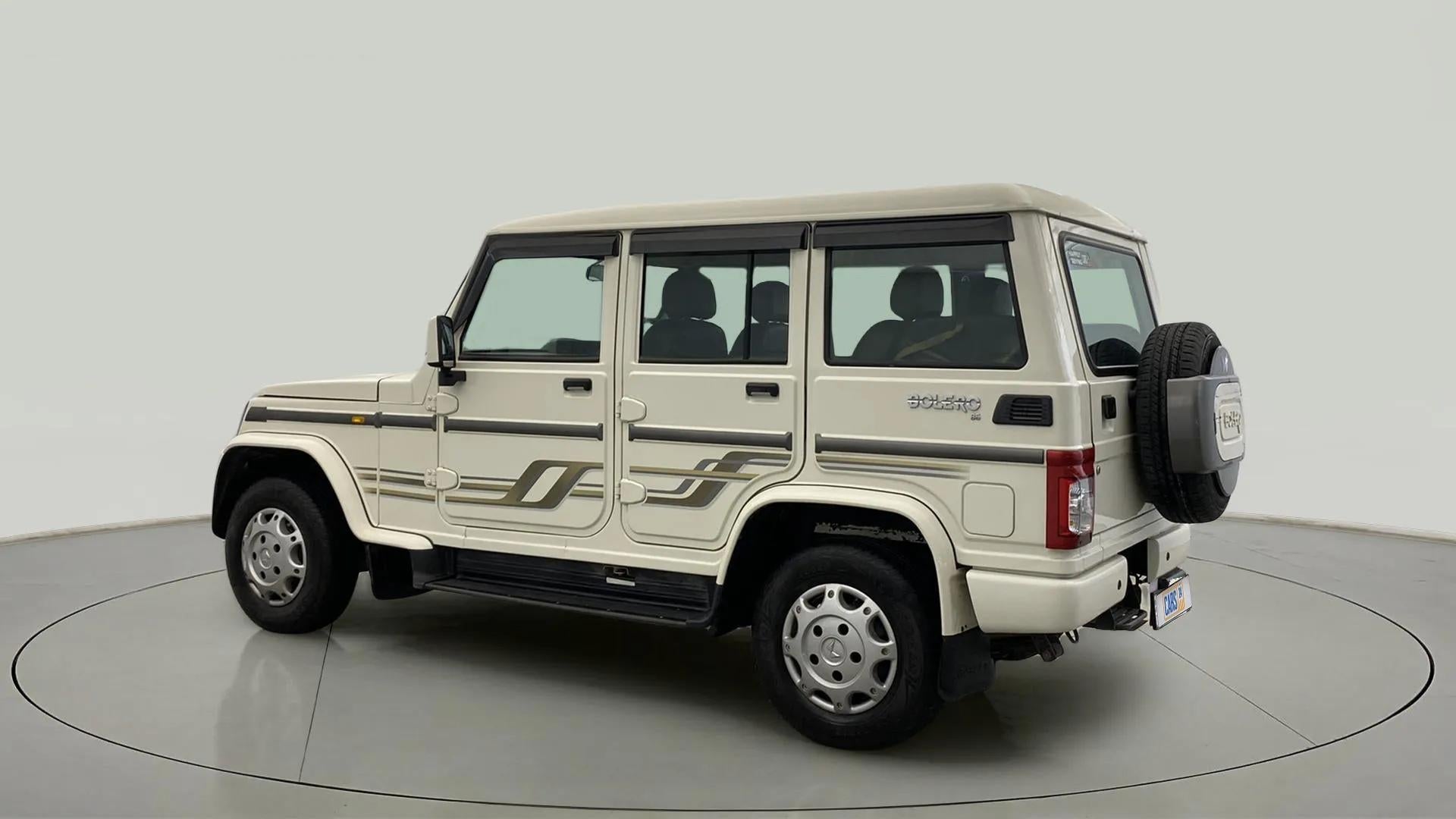 Rear three-quarter view of a diamond white Mahindra Bolero