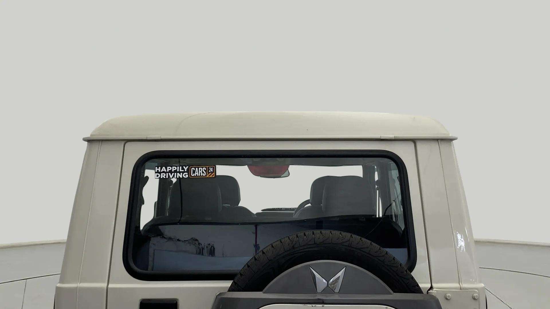 Rear view of a diamond white Mahindra Bolero