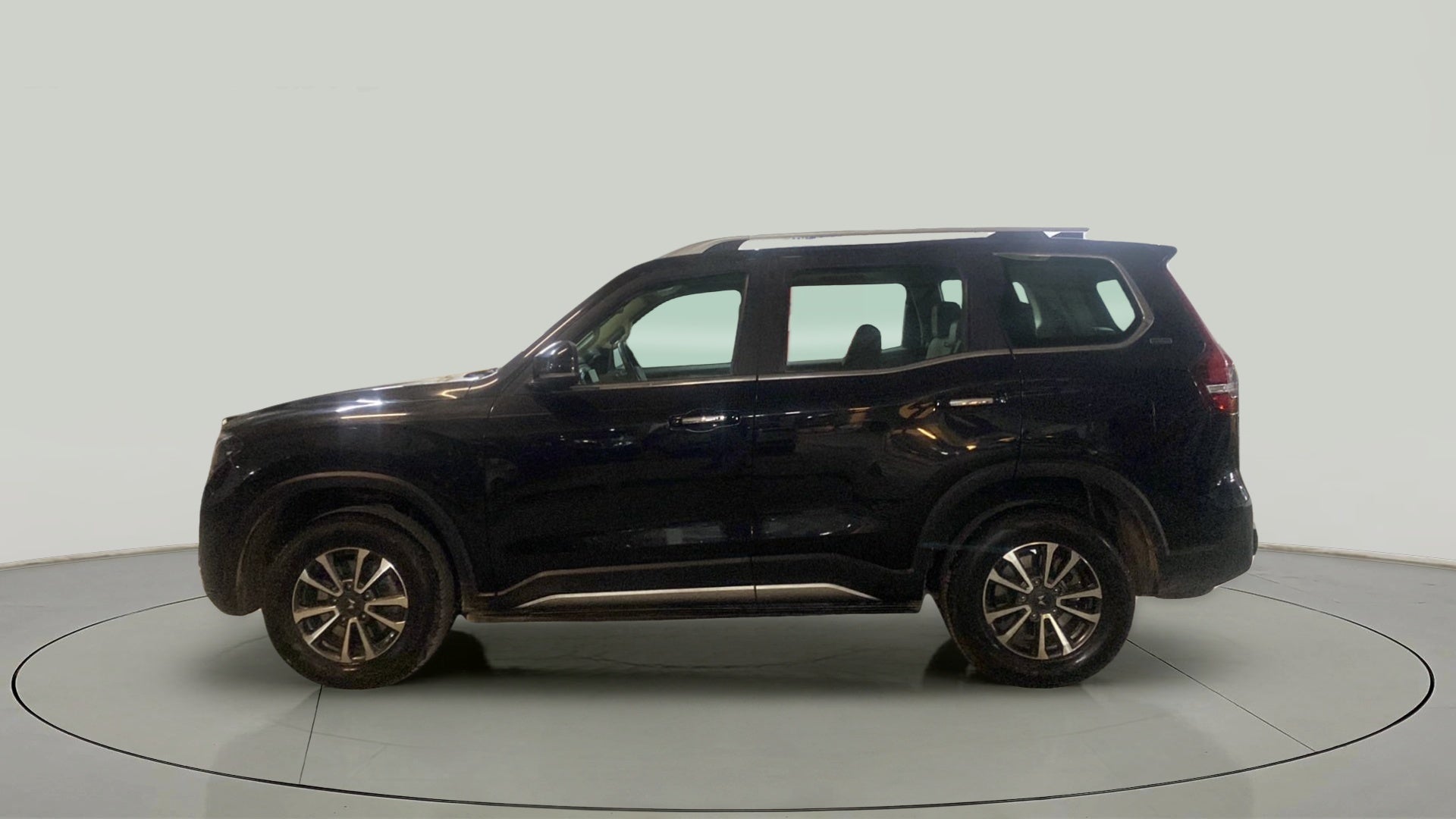 Side view of a deep forest Mahindra Scorpio-N