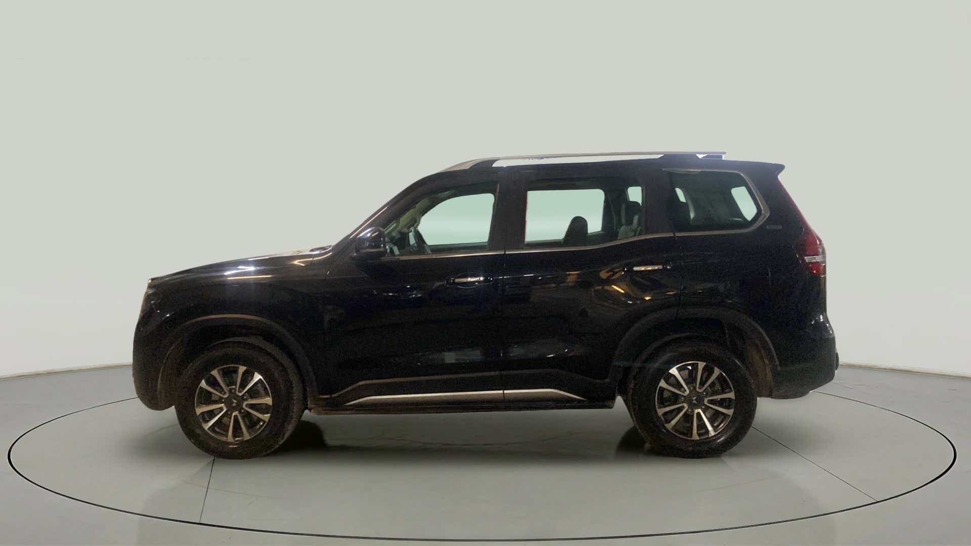 Side view of a deep forest Mahindra Scorpio-N