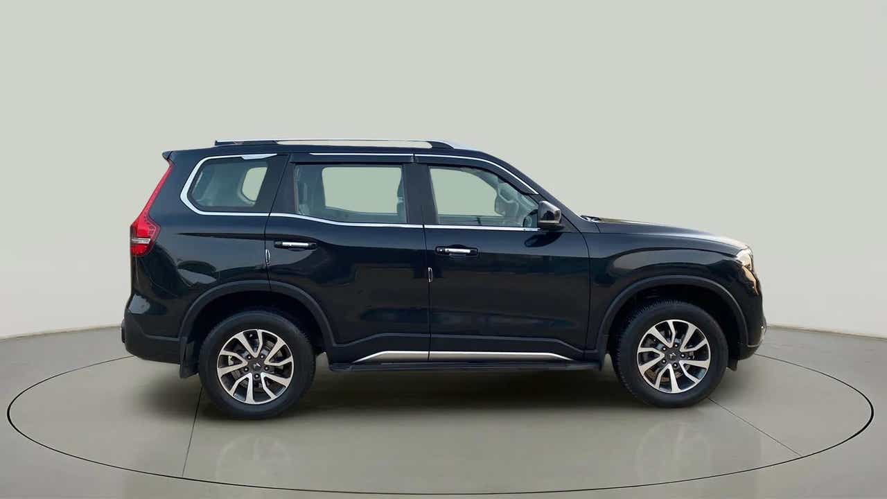 Side view of a deep forest Mahindra Scorpio-N