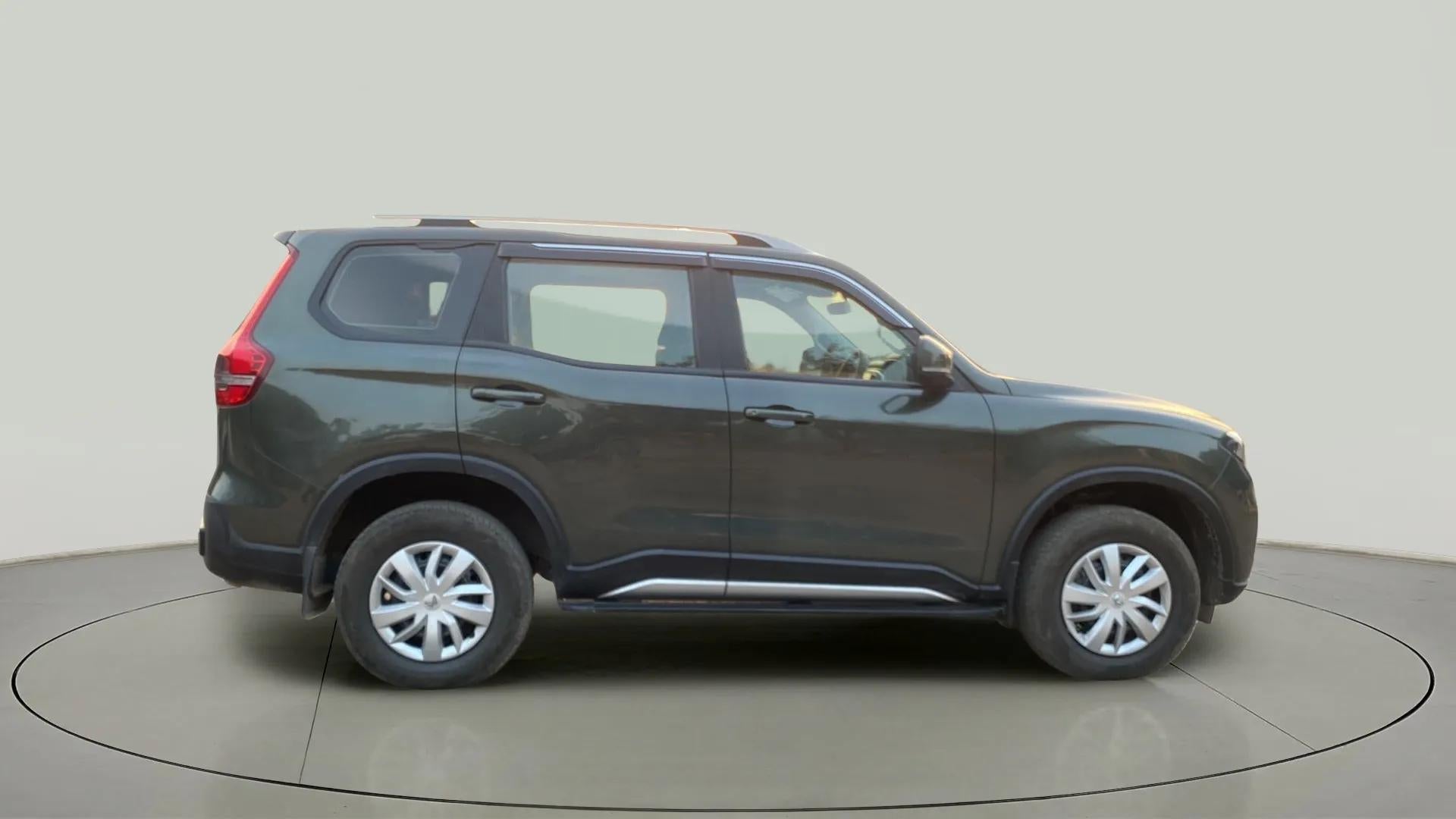 Side view of a deep forest Mahindra Scorpio-N